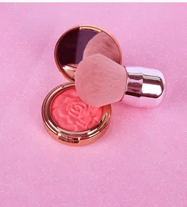 Detailopname van de zachte make-upkwast en de roze bloemmotief blushcompacts.