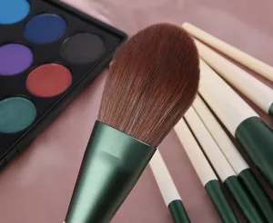 Close-up detail of soft makeup brush set bristles and green handle, studio product shot.
