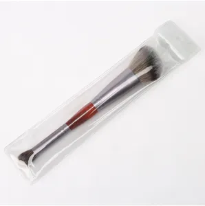 Double-ended makeup brush with soft bristles, wooden handle and metal ferrule detail view.