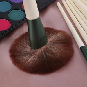 Professional makeup brush set with soft brown bristles and green ferrule for smooth application.
