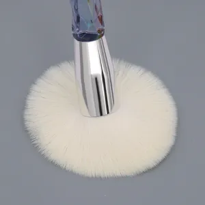 Brocha de maquillaje con mango de cristal, primer plano de cerdas blancas y virola.