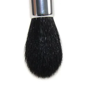 Close-up detail of soft black makeup brush bristles with metallic ferrule for highlighting.