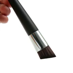 Close-up detail of the angled foundation brush with soft dense bristles and sleek black handle.