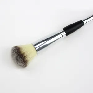 Detailed close-up of a dual-ended makeup brush with soft tri-color bristles and a sleek handle.