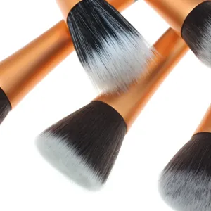 Detailopname van professionele make-upkwasten met oranje handvatten en zachte haren.
