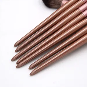 Close-up detail of brown makeup brush handles set featuring smooth metallic finish and elegant design.