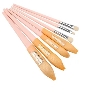 Detailed close-up view of pink makeup brush set with protective mesh on soft bristles.