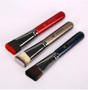 Detailaufnahme von flachen Make-up-Pinseln mit dichten Borsten und farbigen Griffen.