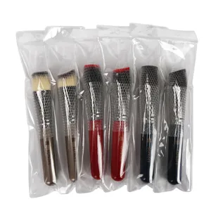 Detailansicht von Make-up-Pinsel mit flachen und angewinkelten Köpfen im praktischen Schutznetz.