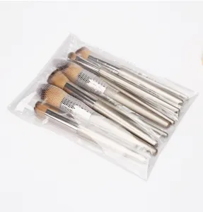 Detail view of champagne gold makeup brushes with protective mesh sleeves in clear packaging.