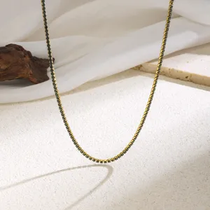 Detail shot of a delicate gold-toned claw chain necklace with dark crystal rhinestones.