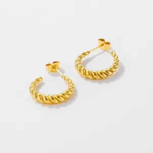 Close-up detail of trendy twisted gold hoop earrings made of durable stainless steel.