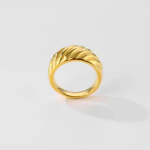 Close-up detail shot of the chic wide gold ring featuring elegant diagonal ribbed twist texture.