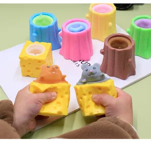 Detailansicht von Händen, die ein buntes Käse-Maus-Becherspielzeug kräftig quetschen