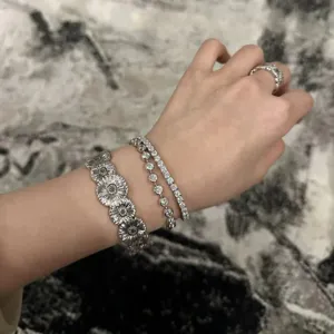 Nahaufnahme der silbernen Moissanit Armbänder im Lagenlook mit Ring am Handgelenk.