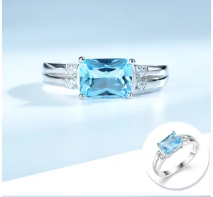 Atemberaubender silberbeschichteter Ring mit einem blauen Hauptstein und funkelnden Zirkonia.