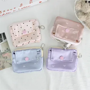 Detail shot of mini satin coin purses with cute bow and dot prints, snap button and zip closure.