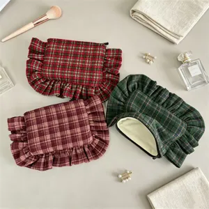 Detailed shot of retro plaid ruffled cosmetic bag, stylish portable zipper storage pouch.