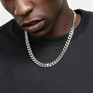 Close-up detail of a bold stainless steel Cuban link chain necklace worn by male model.
