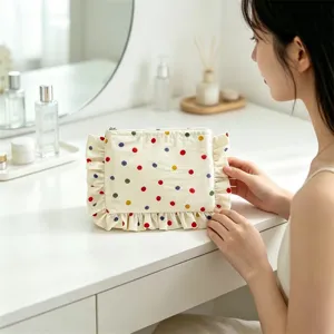 Cute polka dot makeup bag with ruffled trim, portable cosmetic pouch for daily storage.