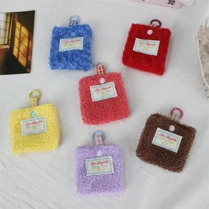 Vista dettagliata del mini portamonete in peluche, morbida custodia con anello metallico.