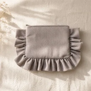 Detailed view of the corduroy ruffle cosmetic pouch, soft texture and cute portable storage design.
