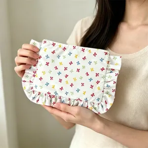 Floral cosmetic pouch with delicate ruffled edges and colorful floral design for daily use.