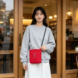 Detailaufnahme einer roten Mini Nylon Umhängetasche mit weißen Punkten in einer gemütlichen Kaffeebar.