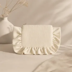 Close-up detail of corduroy cosmetic bag featuring elegant fabric ruffles and secure metal zipper.