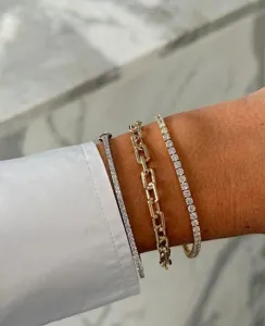 Gestapelde moissanite tennisarmbanden en grove goudkleurige schakelarmband voor dames