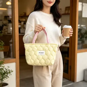 Detailed view of the cute quilted lunch tote bag with pink handles in a cafe scene.