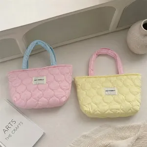 Detailed view of soft quilted lunch tote bags in charming pastel color combinations.