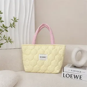 Detailed close-up of the quilted tote bag showcasing soft fabric and delicate stitching texture.