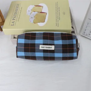 Détail de la trousse à crayons à carreaux rétro en tissu bleu et marron pour papeterie.