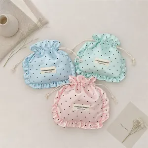 Satin polka dot drawstring pouch with ruffle trim, cute storage bag for jewelry and cosmetics.