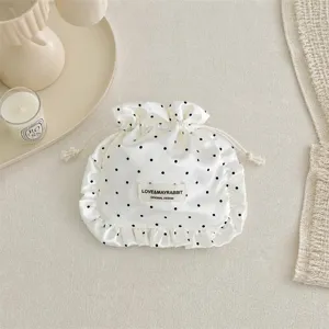 Satin polka dot drawstring pouch detail, ruffled cosmetic jewelry storage bag, aesthetic gift pouch.