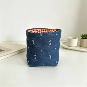 Nahaufnahme des Denim Stoff Tischaufbewahrungskorbs mit rotem Karofutter für Zuhause.