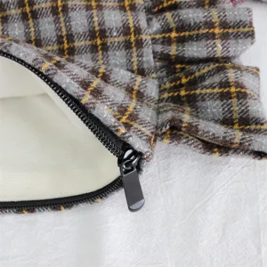 Detailed close-up of the vintage plaid cosmetic bag showcasing zipper and ruffle trim.