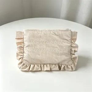 Beige Nylon Kosmetiktasche mit rüschen und bestickten Buchstaben für den täglichen Gebrauch.