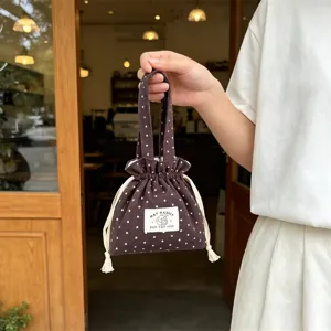 Primer plano detallado de la bonita bolsa de lona marrón con estampado de estrellas y asa.