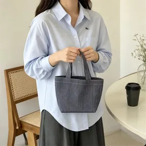 Vista detallada del elegante bolso tote de lona a rayas minimalista para uso diario y trabajo.
