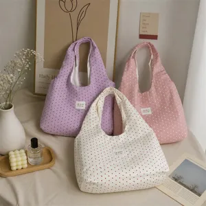 Close-up detail of cozy polka dot tote bags in multiple pastel colors with aesthetic lifestyle props.