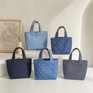 Detalle de mini bolso de mezclilla con estilos lisos, patrones de lazos y bolsos de lona a rayas.