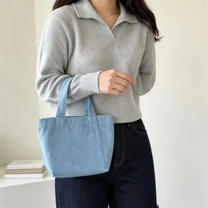 Primer plano de un bolso tote de mezclilla azul claro vintage minimalista para uso diario.