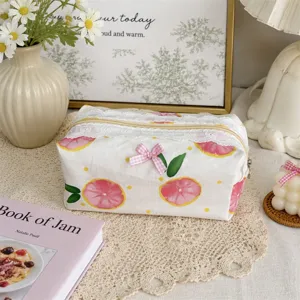 Close-up detail of cute floral cosmetic pouch with white lace trim and pink bow accent.