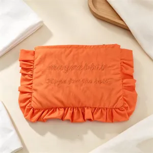 Oranger Nylon Kosmetikbeutel mit süßen Rüschen und bestickten Buchstaben für Damen.