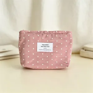 Vista dettagliata della trousse rosa in tessuto stellato, con cerniera e caratteristica etichetta.