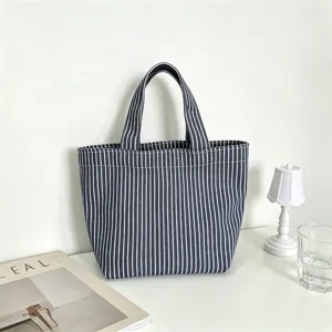 Mini bolso tote de lona a rayas verticales azul y blanco, detalle de bolsa de almuerzo diaria casual.