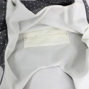 Detailed view of the interior zip pocket of a gray star print canvas tote bag, clean style.