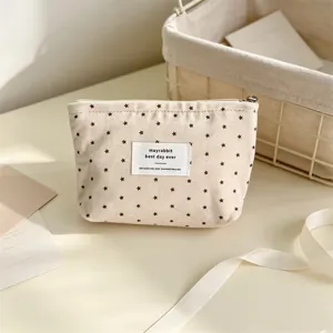 Primo piano di una graziosa borsa cosmetica in tela con stampa di stelle e piccola etichetta.
